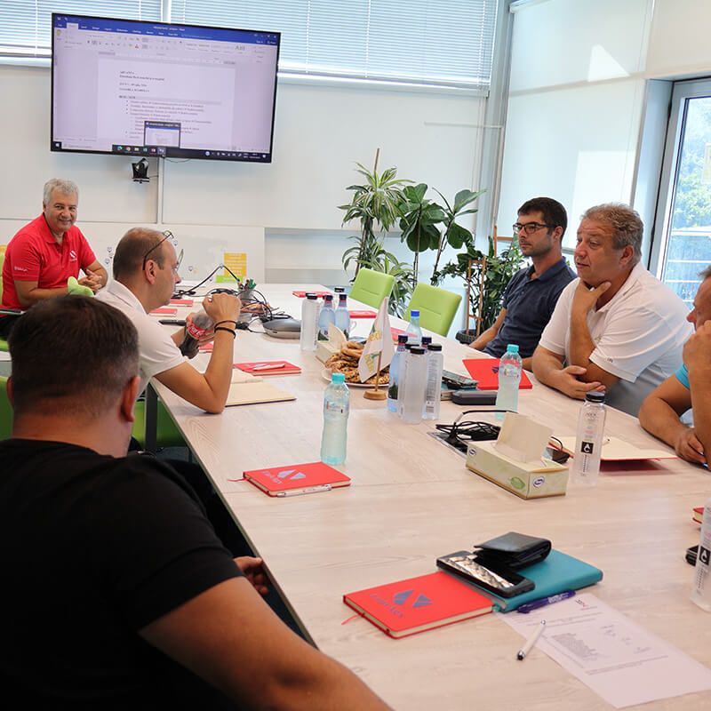 Discuție între participanți la o sesiune de formare, la o masă cu materiale de curs UnivAgx.